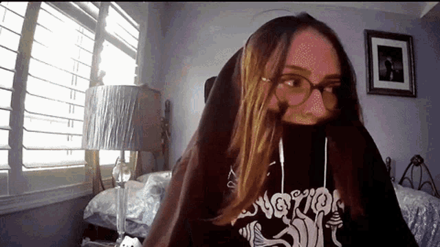 a girl wearing glasses and a hoodie that says ' nightmare '