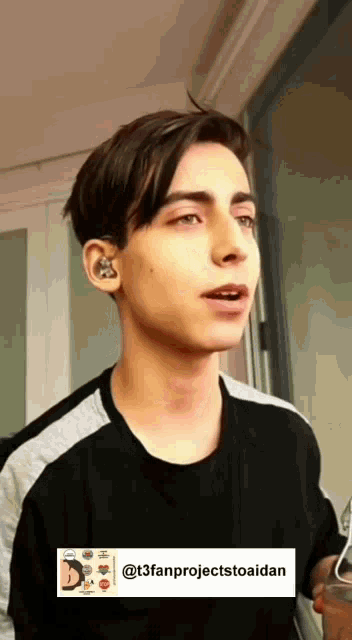 a young man with a tattoo on his ear is looking at something