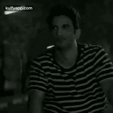 a man in a black and white striped shirt is smiling .