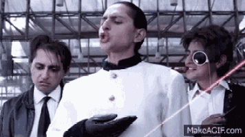 a group of men are standing next to each other and one of them is holding a laser pointer in his hand .
