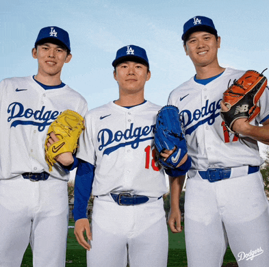 three dodgers baseball players pose for a picture