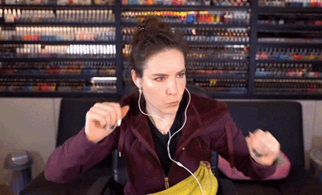 a woman wearing headphones is eating a banana and holding a banana in her hand