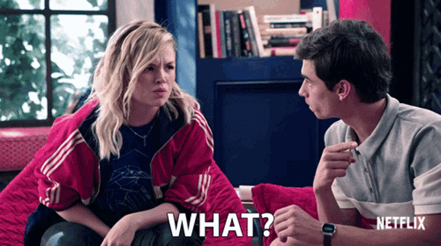 a man and a woman are sitting next to each other and the woman is saying what