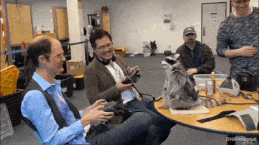 a raccoon sits at a table with a group of men