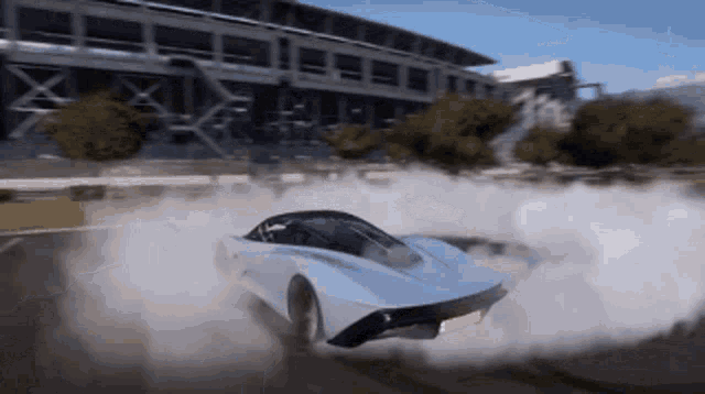 a car is drifting on a track with smoke coming out of the tires