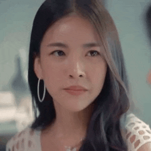 a woman wearing hoop earrings and a necklace is looking at the camera .