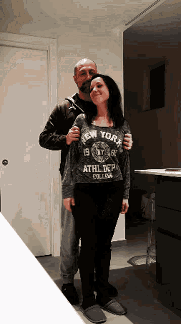 a man is hugging a woman wearing a shirt that says new york