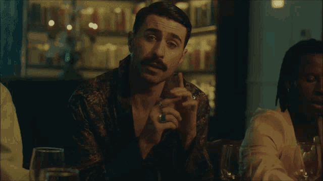 a man with a ring on his finger smoking a cigarette