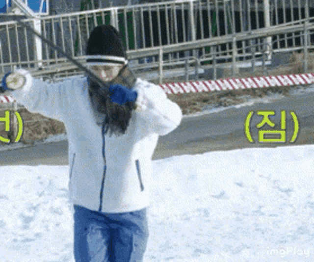 a person in a white jacket and blue pants is standing in the snow with their arms outstretched