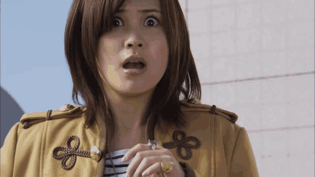 a woman with a surprised look on her face wearing a yellow jacket