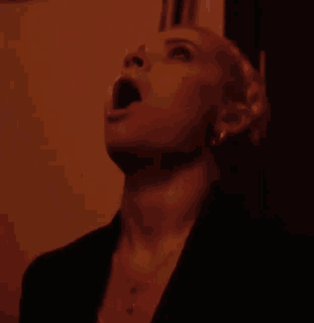a woman with her mouth open looks up at something