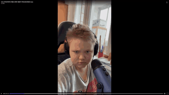 a video of a boy wearing headphones and a microphone is being played