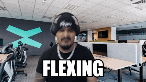 a man wearing headphones and a beanie says " flexing "