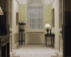 a hallway with a lamp on a table