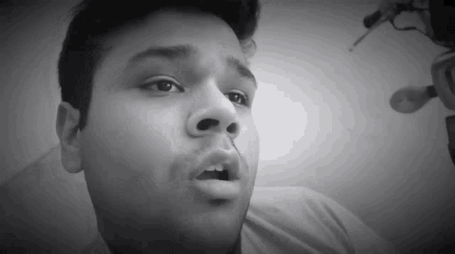 a close up of a man 's face with his mouth open in a black and white photo