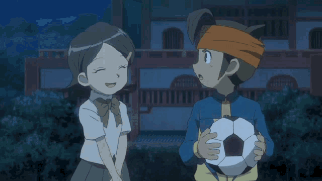 a boy with a lightning bolt on his jacket holds a soccer ball above his head
