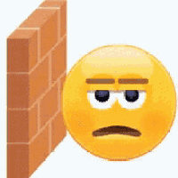 a smiley face is leaning against a brick wall with a sad look on his face .