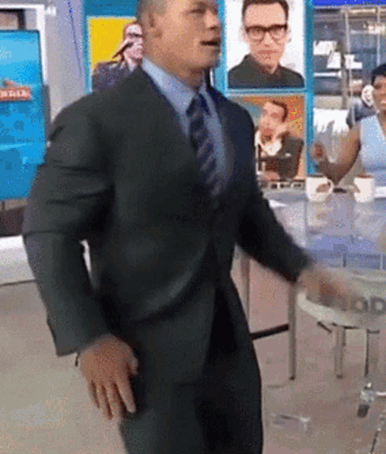 a man in a suit and tie is dancing in front of a sign that says ' nbc '