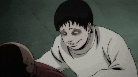 a man in a white sweater is smiling and looking down