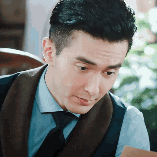 a man in a suit and tie looks at something