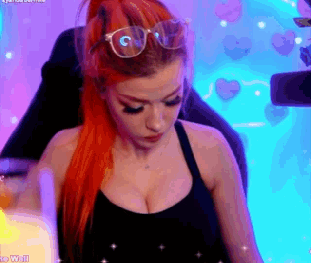 a woman with red hair is wearing sunglasses and a black tank top