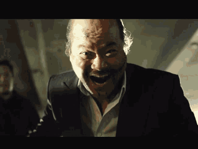 a bald man with a beard is making a face with his mouth open