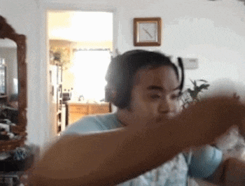 a woman wearing headphones is dancing in front of a mirror in a living room