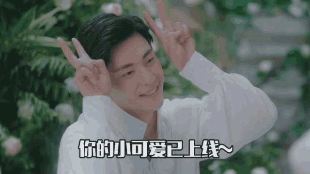 a young man in a white shirt is making a peace sign with his fingers