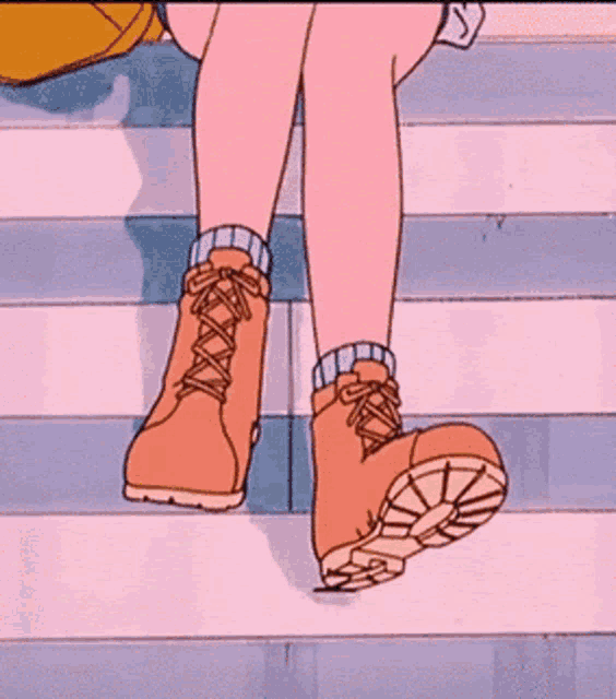 a person wearing a pair of brown boots is walking down stairs .