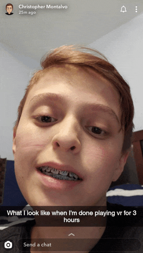 a young boy with braces on his teeth looks like he 's done playing virtual reality for three hours