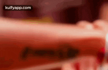 a close up of a person holding a bottle of coca cola in their hand .