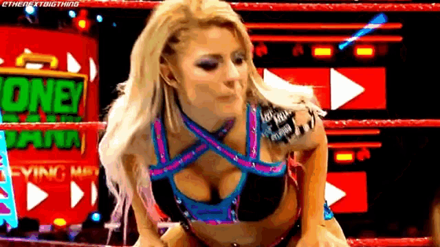 a woman in a bikini is standing in a wrestling ring and making a face .