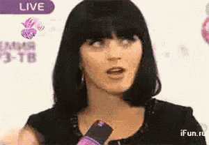 a woman is talking into a microphone in front of a live sign .