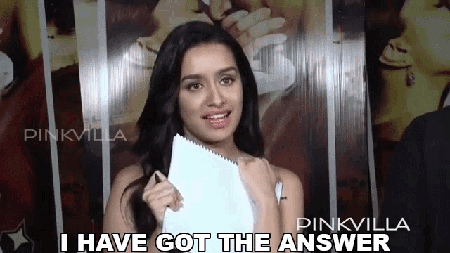 a woman holding a piece of paper that says i have got the answer on it