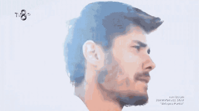 a close up of a man 's face with a tv8 logo in the corner