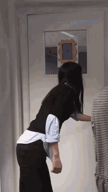 a woman is standing in front of a door with a picture of a door frame on it