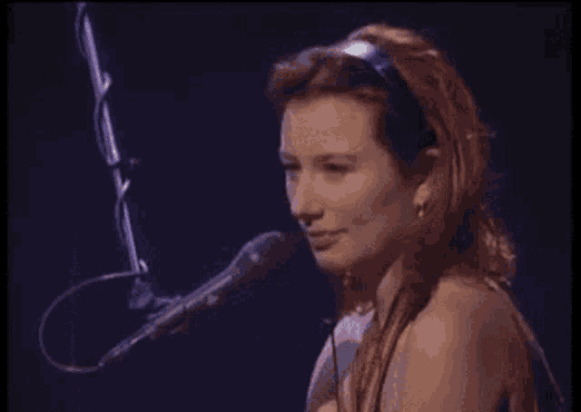 a woman is singing into a microphone on a stage .