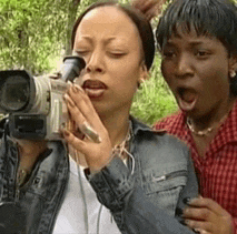 a woman is taking a picture with a video camera while another woman looks on