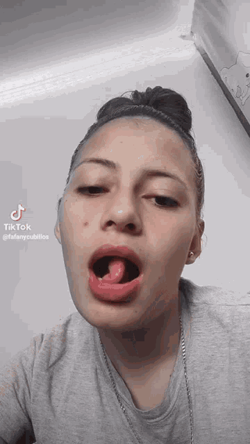 a woman with her tongue sticking out and a tiktok watermark on her face