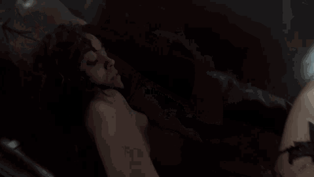 a person is sitting in a dark room with a light shining on them