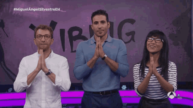 a group of people praying in front of a sign that says vibing