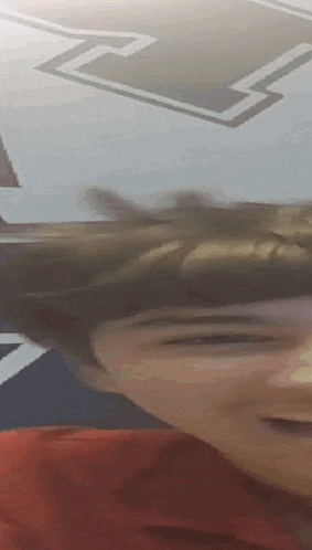 a close up of a person 's face with the letter l visible in the background