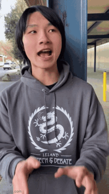 a young man wearing a hoodie that says leland tech & debate on it