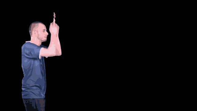 a man in a blue shirt is clapping his hands in front of a black background