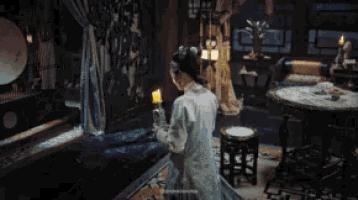 a woman is looking at herself in the mirror .