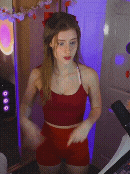 a woman in a red top and red shorts is smiling with her hands folded