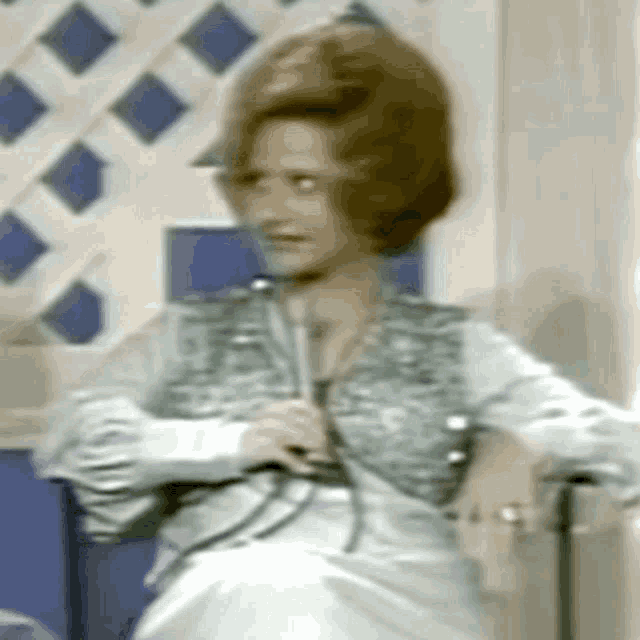 a woman is sitting in a chair holding a microphone in her hand