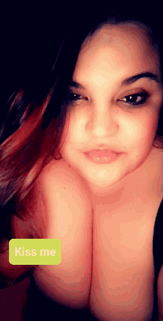 a woman 's breasts are shown with a yellow sticker that says kiss me