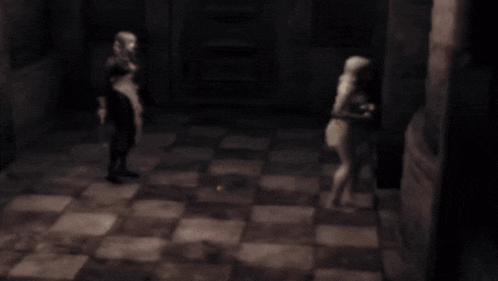 a blurred image of a man and a woman standing in a dark room