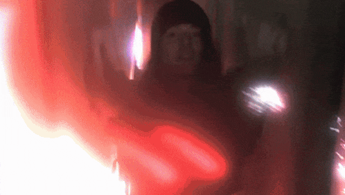 a blurry picture of a person with a red light coming out of their mouth
